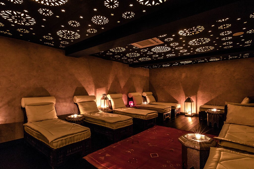 Salle de repos d'un spa oriental, lumières tamisées, avec des lits